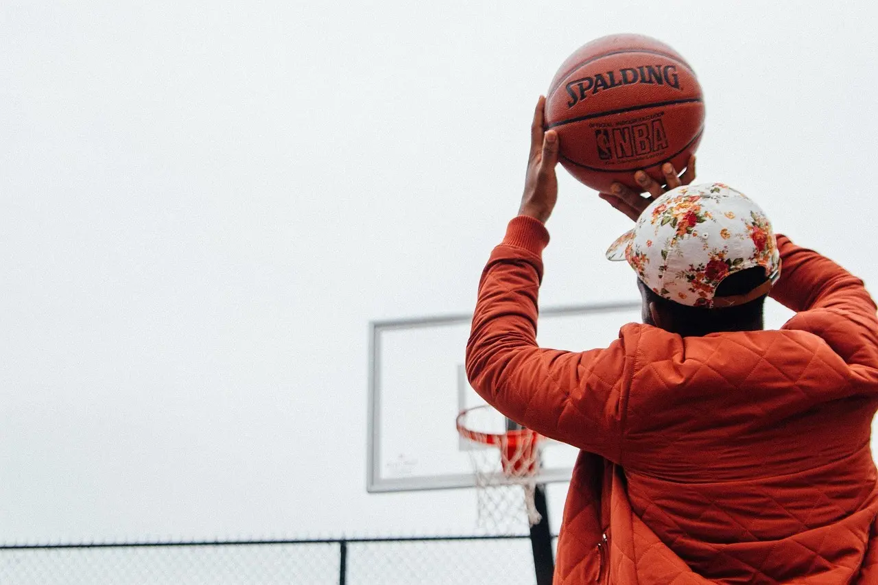 Person med basketball foran udendørs kurv