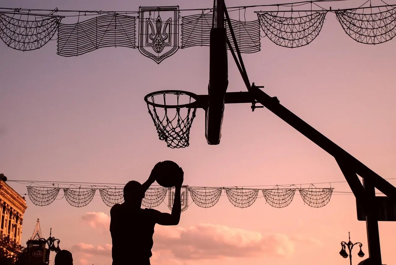 Silhuet der skyder basket ved solnedgang